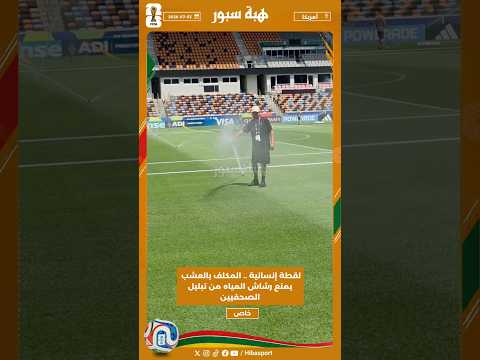 لقطة إنسانية .. المكلف بالعشب يمنع رشاش المياه من تبليل الصحفيين