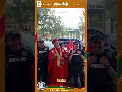 شرطيان أمريكيان يحملان علم المغرب فوق كتفيهما يأخدان صور مع المشجعين المغاربة